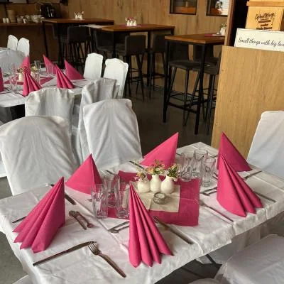 Weiße Stuhlhussen und elegantes Tischgedeck sorgen für feierliche Stimmung