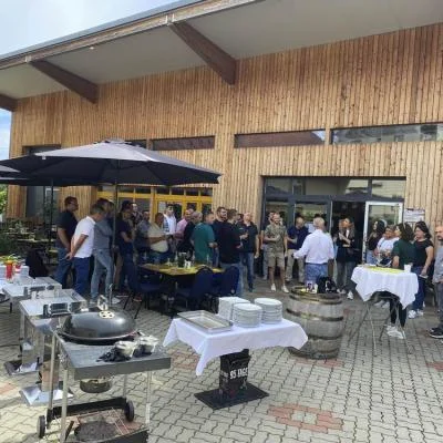 Gäste einer Firmenveranstaltung mit BBQ im Innenhof von Weinbau Eschlböck