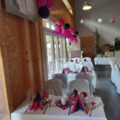 Tischdeko in Firmenfarben und eleganten Stuhlhussen